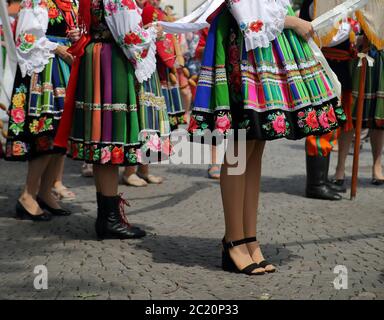 Einheimische Mädchen in schönen Trachten kleiden sich aus Lowicz in Polen, während sie an der jährlichen Fronleichnamsprozession teilnehmen. Stockfoto