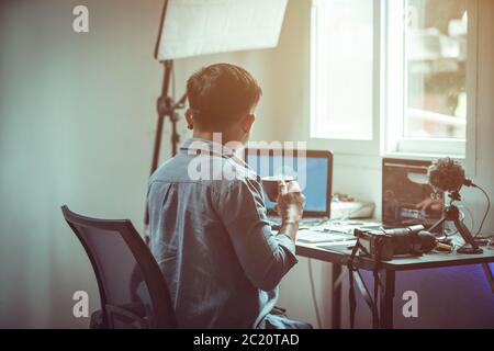 Junge männliche Content Creator arbeitet von zu Hause aus die Auswirkungen des Ausbruchs des Coronavirus oder Covid-19 Stockfoto