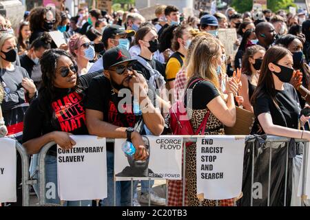 Die Demonstranten schauen während einer Demonstration auf, während sie marschieren.Tausende Demonstranten versammeln sich auf dem Millennium Square im Rahmen der Kampagne Black Lives Matter, um gegen Rassismus in Großbritannien und die Ermordung von George Floyd durch die Polizei in den USA zu protestieren. Stockfoto