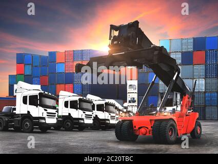 Am Hafen arbeitet der Gabelstapler, um den Container-Kasten im Stapelhof hochzuheben Stockfoto