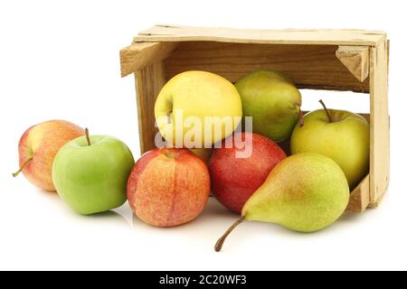 Frisch geerntete Birnen und Äpfel in einer Holzkiste auf weißem Hintergrund Stockfoto