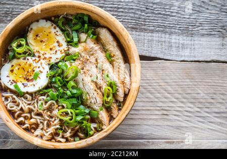 Schüssel mit Hühnerramen-Suppe auf dem Holztisch Stockfoto