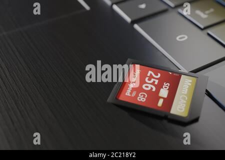 Speicherkarte mit hoher Kapazität auf Laptop-Nahaufnahme. SDXC 256 gb. Modernes Storage-Device-Konzept. Ansicht von oben. Tastaturtasten im Rahmen. Selektiver Fokus Stockfoto