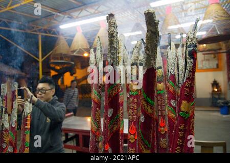 Mann zündet Räucherstäbchen im Hong Kong Tempel an Stockfoto