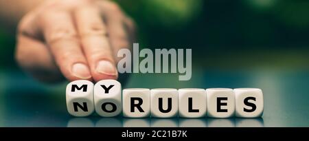 Hand dreht Würfel und ändert den Ausdruck "keine Regeln" in "Meine Regeln". Stockfoto