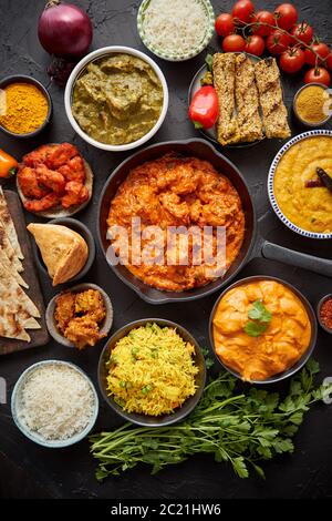 Verschiedene indische Gerichte auf einem Tisch. Würziges Huhn Tikka Masala in Eisentopf Stockfoto