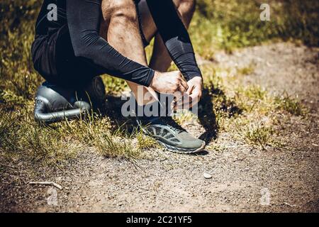 Junge Sportler auf Sport Schuhe Schnürsenkel binden. Fit, Fitness, Bewegung, Training und gesunde Lebensweise. Stockfoto