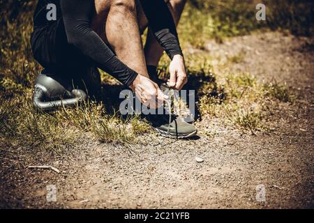 Junge Sportler auf Sport Schuhe Schnürsenkel binden. Fit, Fitness, Bewegung, Training und gesunde Lebensweise. Stockfoto