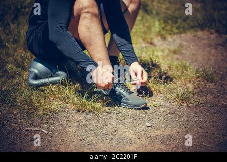 Junge Sportler auf Sport Schuhe Schnürsenkel binden. Fit, Fitness, Bewegung, Training und gesunde Lebensweise. Stockfoto