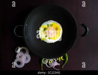 Food Photography of Egg garniert mit kühlen, Zwiebel und Curry Blätter in der Tischplatte sieht lecker und lecker. Stockfoto