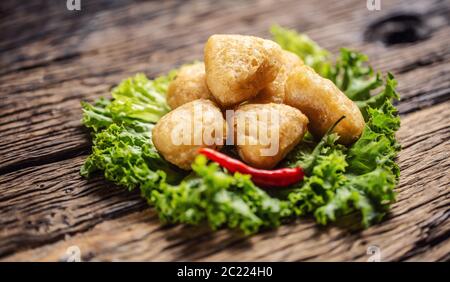 Würzige Käsewürger mit frischem Chili auf Salatblatt Stockfoto