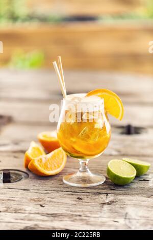 Bierlimonade im Glas mit frisch geschnittener Orange, Eis und Papierhalmen Stockfoto