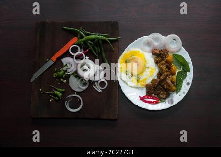 Food Photography of Egg garniert mit kühlen, Zwiebel und Curry Blätter in der Tischplatte sieht lecker und lecker. Stockfoto