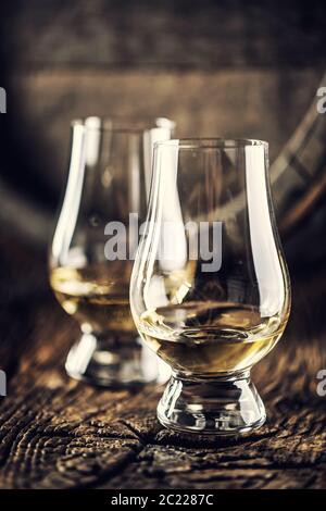 Zwei Glencairn Whisky-Tasting-Gläser auf Vintage-Holz und dunklem Holzfass im Hintergrund Stockfoto