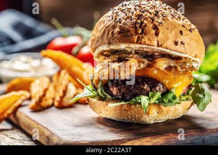 Hamburger mit karamellisierter Zwiebel, Rucola und geschmolzenem Käse Stockfoto