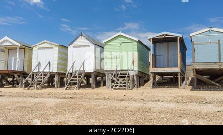 Reihe von Strandhütten entlang des Kiesstrandes an einem sonnigen Tag. Shoeburyness, Southend on Sea, Essex Stockfoto