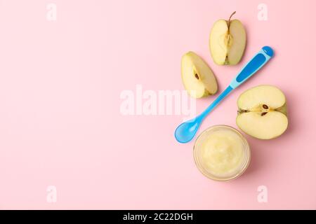 Gemüsebrei, Äpfel und Löffel auf rosa Hintergrund. Babynahrung Stockfoto