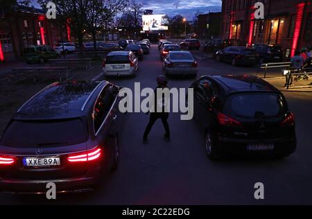 Linkoping, Schweden 20200425 Stanley Kubricks "The Shining" wird in dieser Corona Times in einem Drive-in-Kino im Zentrum von Linköping am Samstagabend gezeigt. Die Mitarbeiter auf Rollschullaufbahn bestellen während des Films Süßigkeiten und Popcorn. Foto Jeppe Gustafsson Stockfoto