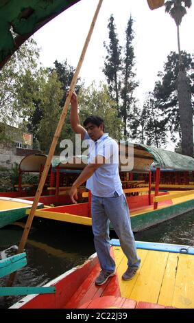 Die Insel der Puppen (La Isla de las Muñecas) kleine Inseln im Xochimilco-See, Mexiko-Stadt, Mexiko mit Mann rudern ein Boot Stockfoto