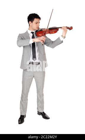 Ein junger stattlicher Mann in einem grauen Anzug Violine zu spielen, konzentriert, bei weißem Hintergrund Stockfoto