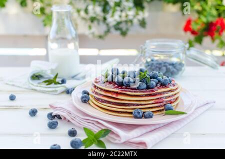 Delish Frühstück mit frischem Obst bei der Gartenparty, aussen mit Blumen hinter und frischen Kräutern auf der Oberseite Stockfoto