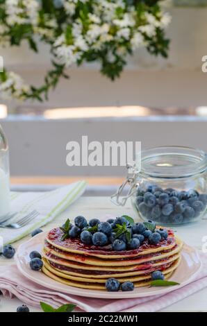 Delish Frühstück mit frischem Obst bei der Gartenparty, aussen mit Blumen hinter und frischen Kräutern auf der Oberseite Stockfoto
