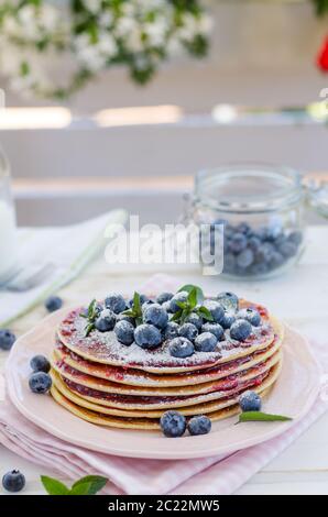 Delish Frühstück mit frischem Obst bei der Gartenparty, aussen mit Blumen hinter und frischen Kräutern auf der Oberseite Stockfoto