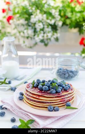 Delish Frühstück mit frischem Obst bei der Gartenparty, aussen mit Blumen hinter und frischen Kräutern auf der Oberseite Stockfoto
