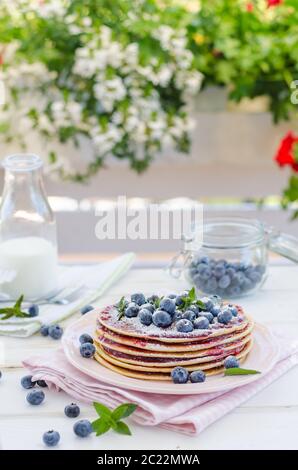 Delish Frühstück mit frischem Obst bei der Gartenparty, aussen mit Blumen hinter und frischen Kräutern auf der Oberseite Stockfoto