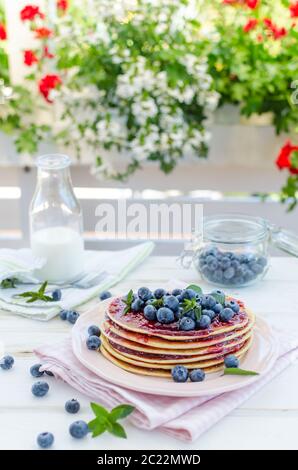 Delish Frühstück mit frischem Obst bei der Gartenparty, aussen mit Blumen hinter und frischen Kräutern auf der Oberseite Stockfoto