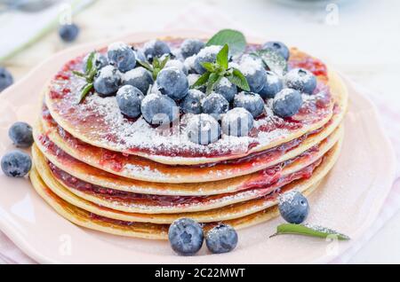Delish Frühstück mit frischem Obst bei der Gartenparty, aussen mit Blumen hinter und frischen Kräutern auf der Oberseite Stockfoto