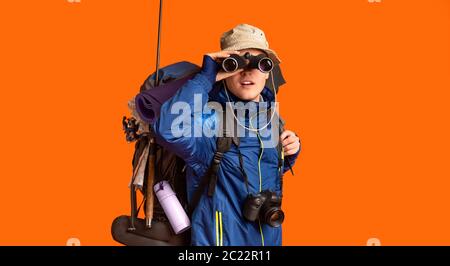 Aufgeregt Backpacker Blick auf Kamera durch Fernglas Stockfoto