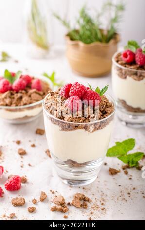 Käsekuchen im Glas mit Himbeeren und Kräutern Stockfoto