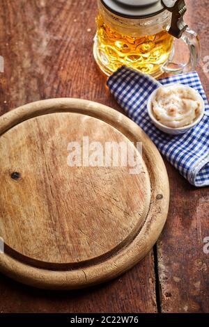 Leere alte runde Holzplatte mit Maß Bier, Serviette und Schüssel von dip auf einem alten Holz-, gesehen von oben für Essen Platzierung Stockfoto