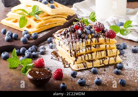 Hausgemachte Waffeln mit Beeren garniert mit Schokolade Stockfoto