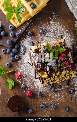 Hausgemachte Waffeln mit Beeren garniert mit Schokolade Stockfoto