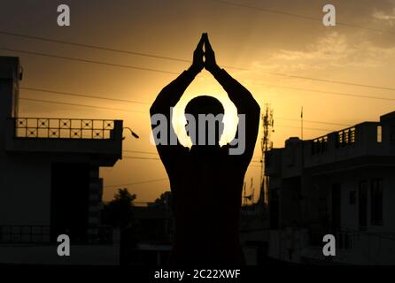 Beawar, Rajasthan, Indien, 16. Juni 2020: Silhouette einer Person, die "Surya Namaskar" Yoga während des Sonnenuntergangs vor dem 6. Internationalen Yoga-Tag, in Beawar. Yoga ist eine körperliche, geistige und spirituelle Praxis, die ihren Ursprung in Indien hat. Kredit: Sumit Saraswat/Alamy Live Nachrichten Stockfoto