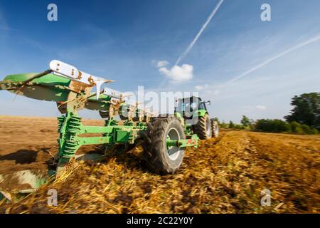 Traktor auf dem Hof, moderne landwirtschaftliche Verkehr, Bauer arbeiten im Feld, Traktor auf einen Sonnenuntergang im Hintergrund, in der Bearbeitung des Landes, Agricult Stockfoto