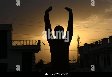 Beawar, Rajasthan, Indien, 16. Juni 2020: Silhouette einer Person, die "Surya Namaskar" Yoga während des Sonnenuntergangs vor dem 6. Internationalen Yoga-Tag, in Beawar. Yoga ist eine körperliche, geistige und spirituelle Praxis, die ihren Ursprung in Indien hat. Kredit: Sumit Saraswat/Alamy Live Nachrichten Stockfoto