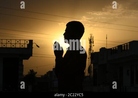 Beawar, Rajasthan, Indien, 16. Juni 2020: Silhouette einer Person, die "Surya Namaskar" Yoga während des Sonnenuntergangs vor dem 6. Internationalen Yoga-Tag, in Beawar. Yoga ist eine körperliche, geistige und spirituelle Praxis, die ihren Ursprung in Indien hat. Kredit: Sumit Saraswat/Alamy Live Nachrichten Stockfoto