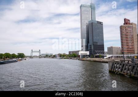 Nieuwe Maas läuft durch das Zentrum von Rotterdam in den Niederlanden. De Haf Eisenbahnbrücke und hohe Bürogebäude sichtbar Stockfoto