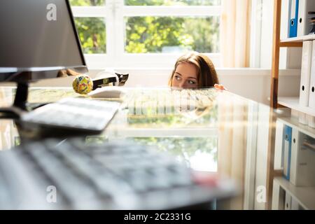 Nahaufnahme der Angst Geschäftsfrau, der sich hinter dem Schreibtisch mit Laptop Stockfoto