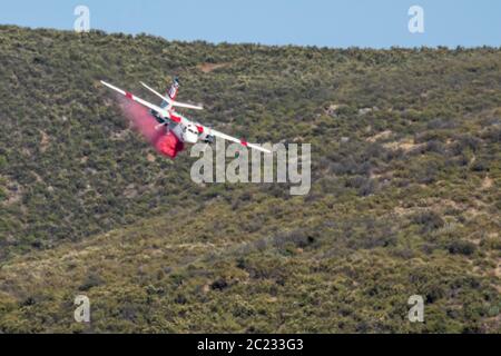 Winchester, CA USA - 14. Juni 2020: CAL Fire Aircraft fällt feuerhemmend auf einem trockenen Waldbrand auf einem Hügel in der Nähe von Winchester, Kalifornien. Stockfoto