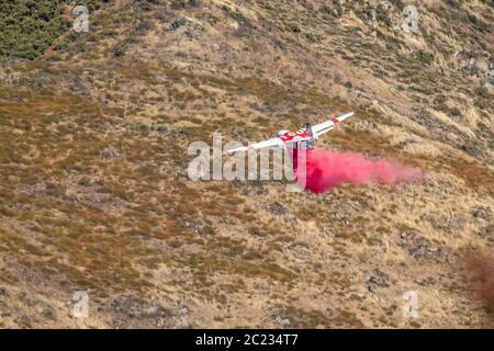 Winchester, CA USA - 14. Juni 2020: CAL Fire Aircraft fällt feuerhemmend auf einem trockenen Waldbrand auf einem Hügel in der Nähe von Winchester, Kalifornien. Stockfoto