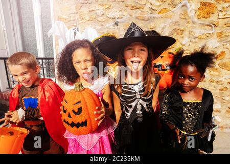 Close Portrait des Mädchens über große Gruppe von Kindern Jungen und Mädchen in Halloween-Kostümen stehen zusammen und zeigen gruselige Gesten, die auf die Kamera schauen Stockfoto