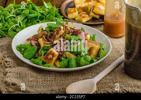 Kartoffel-Gnocchi mit Sommer-Salat, Speck und Röstzwiebeln. Gnocchi gekocht und dann auf Pfanne für Golden knusprig gebraten Stockfoto