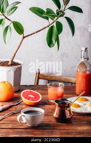 Gesundes Frühstück mit türkischen Kaffee, Spiegeleier, Saft und Obst Stockfoto