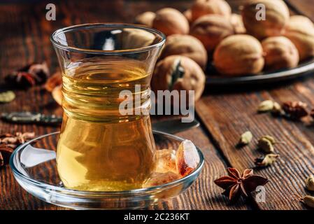 Arabischer Kaffee mit Kardamom, Sternanis und getrocknete Kalk in der orientalischen Glas über Holz- Oberfläche Stockfoto