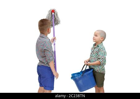 Zwei kaukasischen Junge stehend auf einem weißen Hintergrund isoliert und mit einem Eimer Wasser und einem MOP für die Reinigung Stockfoto