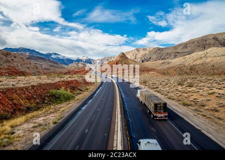 Blick auf eine endlose gerade Straße durch die Wüste in den USA läuft Stockfoto